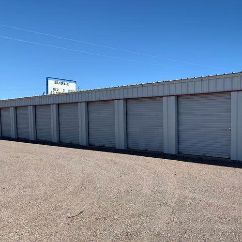 self storage units with gravel parking under a blue sky